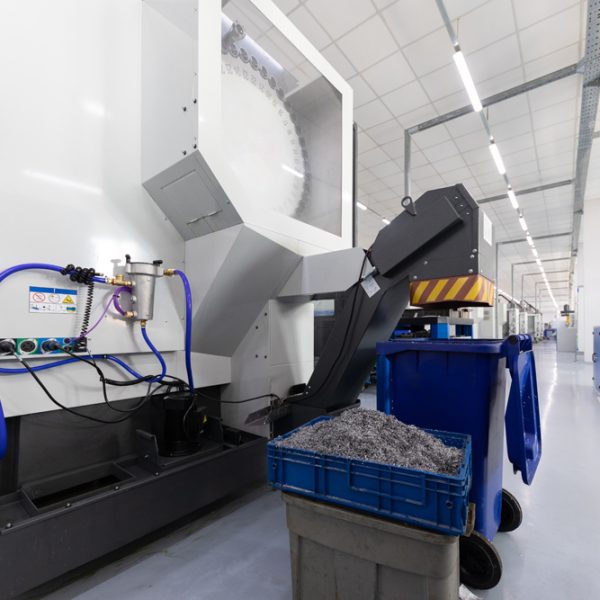 Inside of factory unit with new modern computerized equipment and box with metal shavings